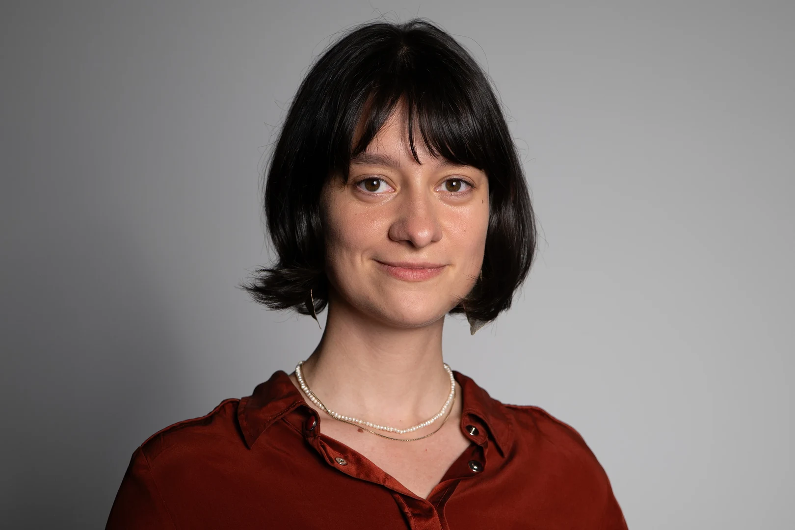 Eine Wissenschaftlerin und ein Wissenschaftler arbeiten hinter einer Glasfassade und mischen Chemikalien mit Großgeräten.